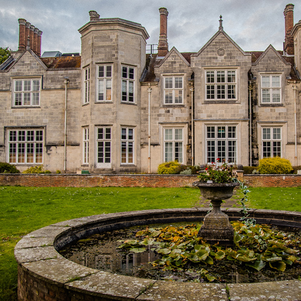 Exterior of Stoke Court, a stone building with tall chimneys
