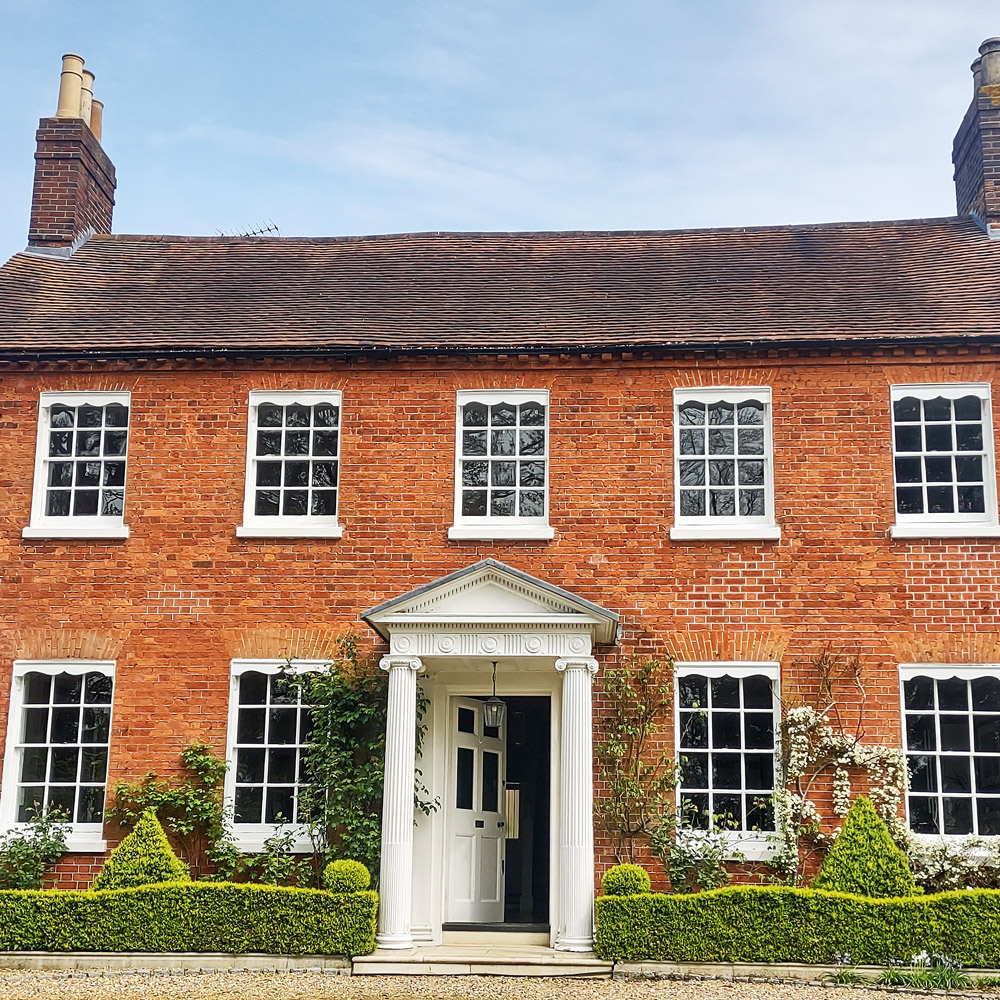 Uplands, a brick built building with white columns framing the front door